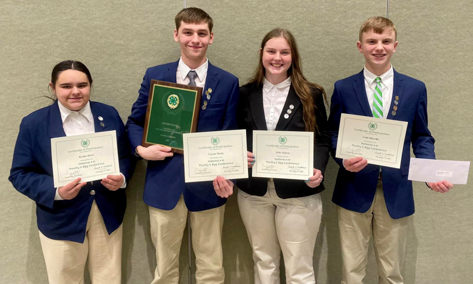 Picture of smiling 4-H members holding awards from the National Poultry Judging competition